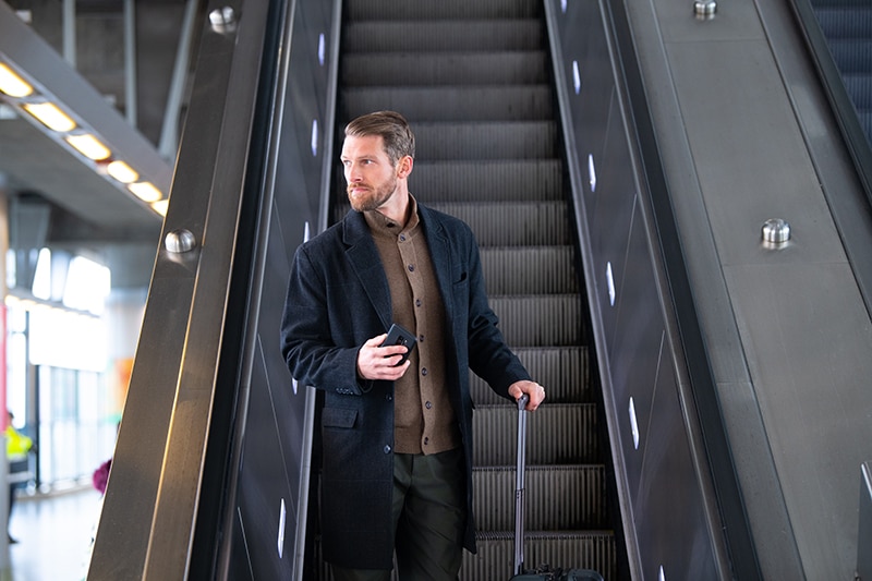 Man on escalator with suitcase 
