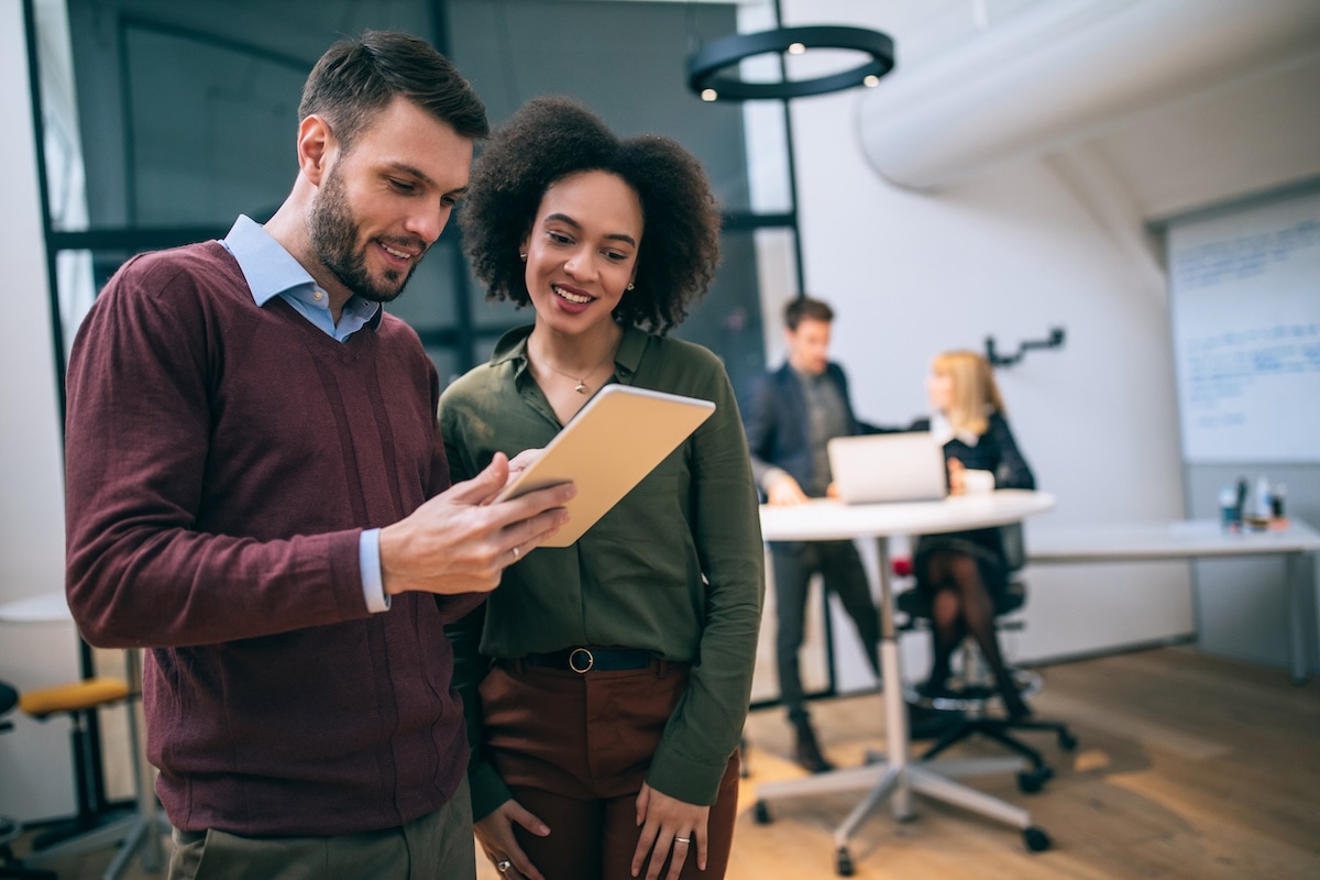 man and woman looking at tablet