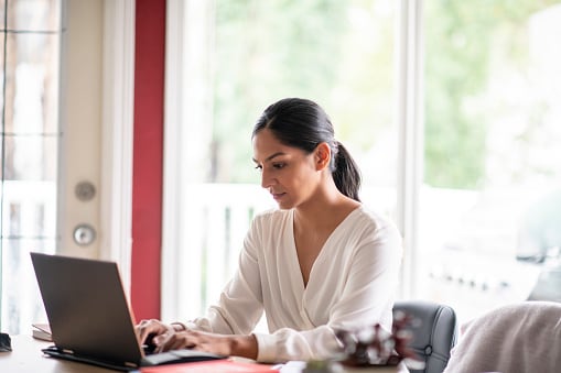 Lady in white shirt sitting at her laptop 