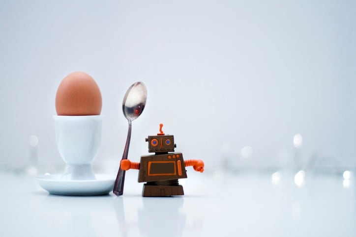 Little robot standing next to a boiled egg