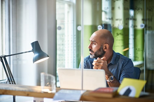 Man sitting at desk looking out window