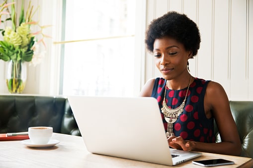 Lady in sleeveless dressing sitting at her laptop  