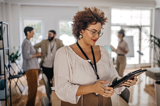 Lady in work environment looking a large tablet