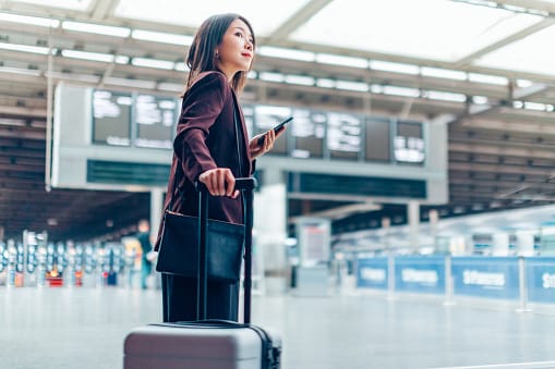 Lady standing in airport with her suitcase