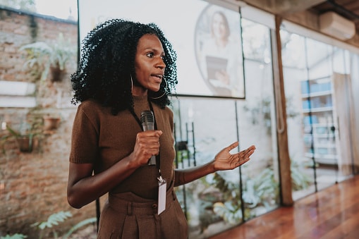 Lady in brown dress with microphone in her hand