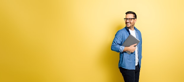 Man in blue shirt and wearing glasses hold laptop