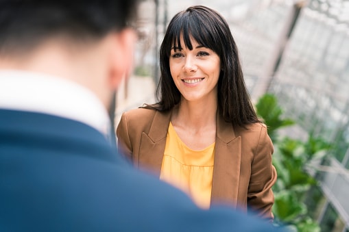 Lady with dark hair and brown jacket